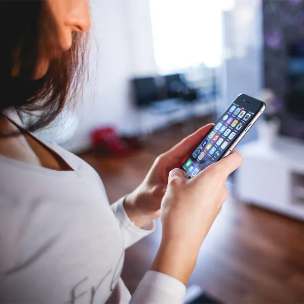 Frau mit Smartphone auf dem Sofa zu Hause